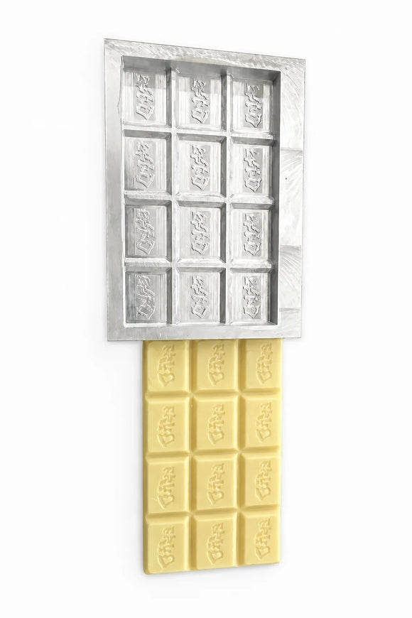 Finished white chocolate test piece beside a custom chocolate mold prototype
