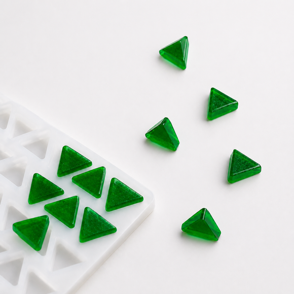 1.6mL triangle gummy mold with 220 cavities and rearranged emerald green triangular gummies on a white background